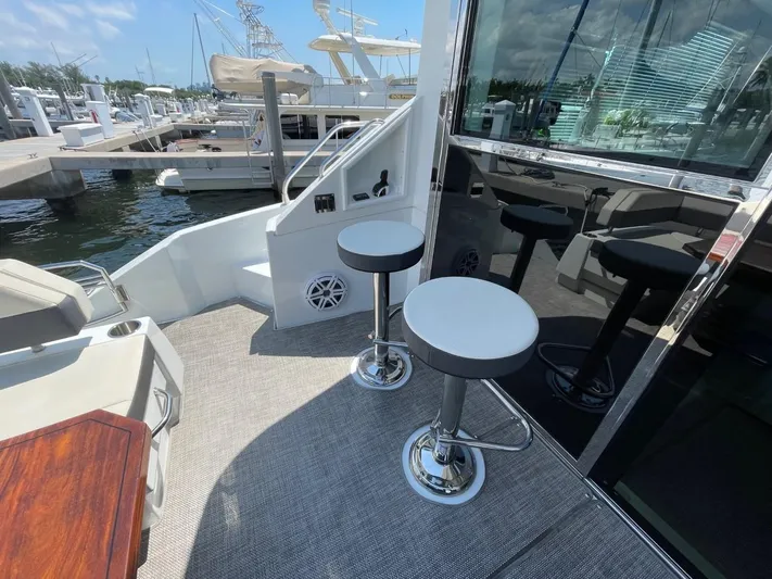  Yacht Photos Pics 2019 Cruisers 50 Cantius yacht deck with bar stools and marina view.