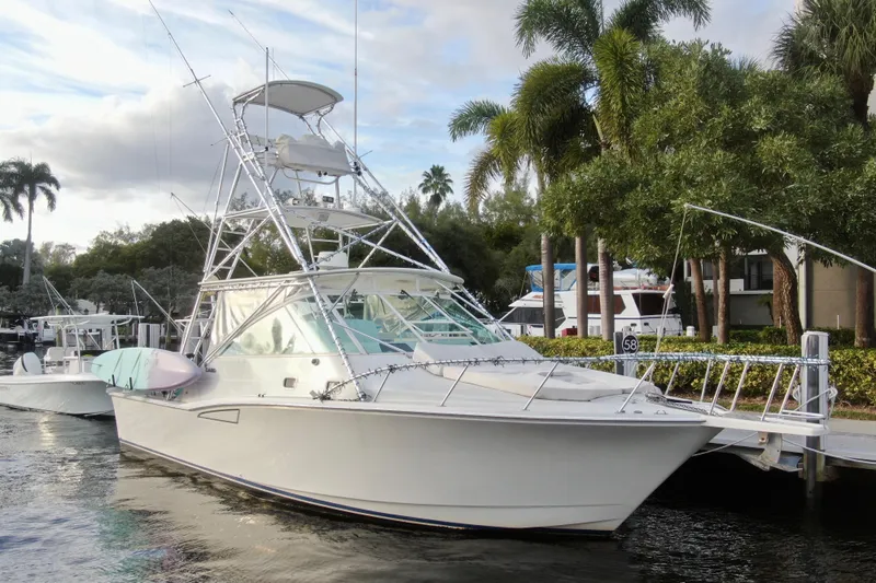 Island Oasis Yacht Photos Pics 2001 Cabo 35 Express boat docked near palm trees and waterfront homes.