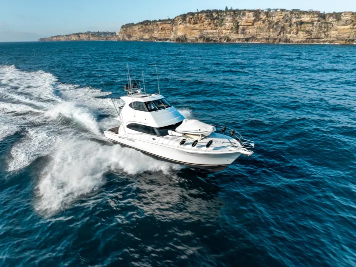 Riviera 61 Enclosed Flybridge Yacht Photos Pics Riviera 61 Enclosed Flybridge yacht cruising on ocean near rocky coastline, 2011 model.