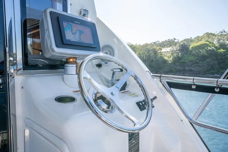 Riviera 61 Enclosed Flybridge Yacht Photos Pics Helm of 2011 Riviera 61 Enclosed Flybridge with navigation display and steering wheel.