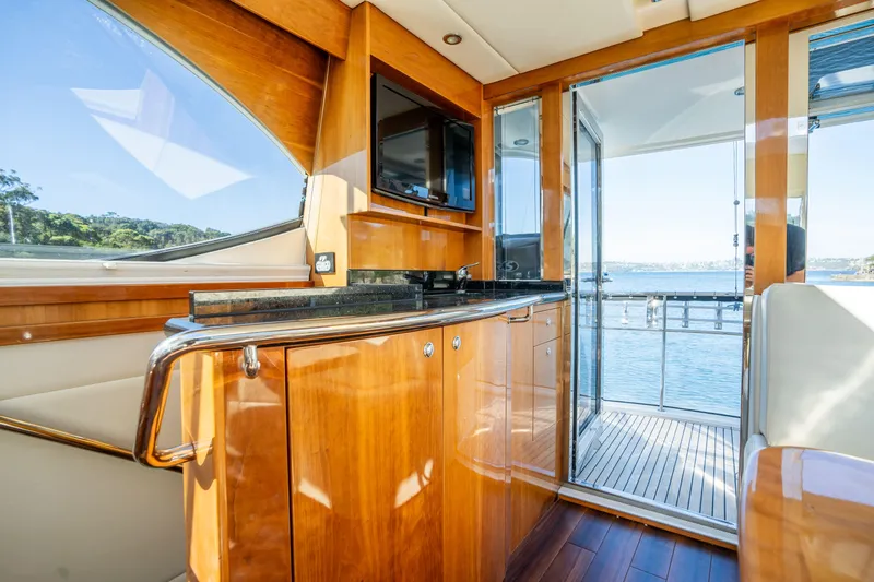 Riviera 61 Enclosed Flybridge Yacht Photos Pics Luxurious interior of 2011 Riviera 61 Enclosed Flybridge yacht with wood finish and ocean view.