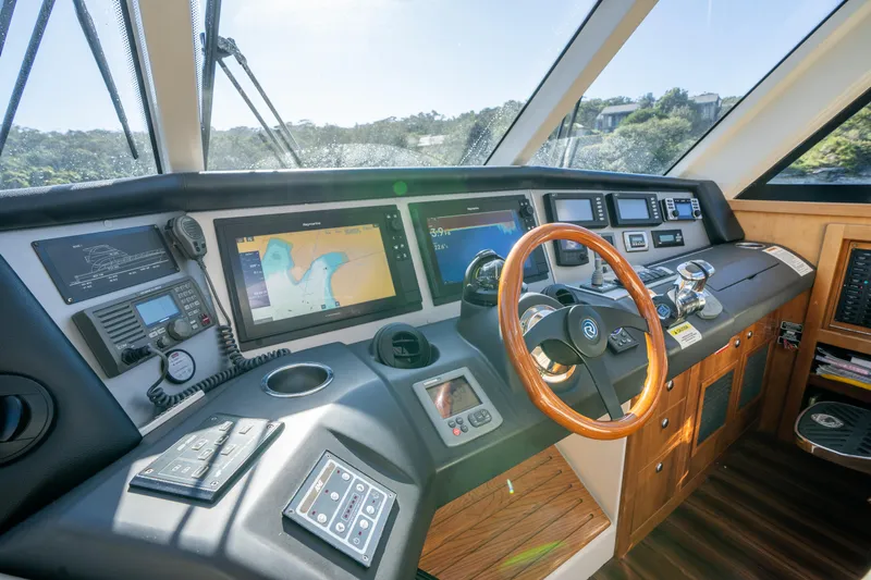 Riviera 61 Enclosed Flybridge Yacht Photos Pics Helm of 2011 Riviera 61 Enclosed Flybridge with advanced navigation systems and wooden steering wheel.