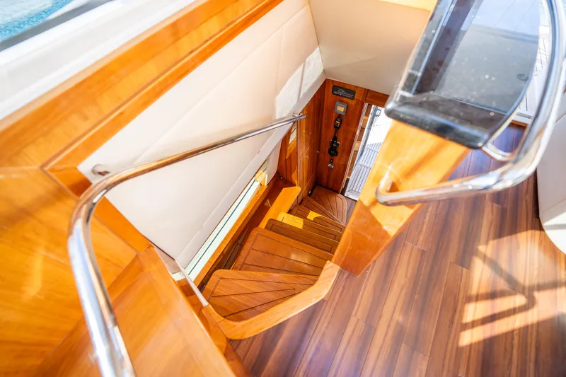 Riviera 61 Enclosed Flybridge Yacht Photos Pics Staircase inside 2011 Riviera 61 Enclosed Flybridge yacht with wooden flooring and metal railings.