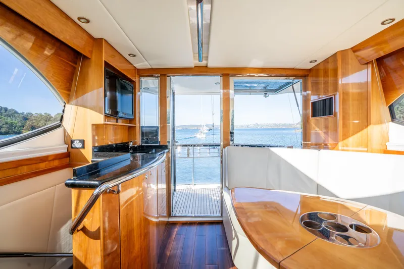 Riviera 61 Enclosed Flybridge Yacht Photos Pics Luxurious interior of 2011 Riviera 61 Enclosed Flybridge yacht with wood finishes and ocean view.