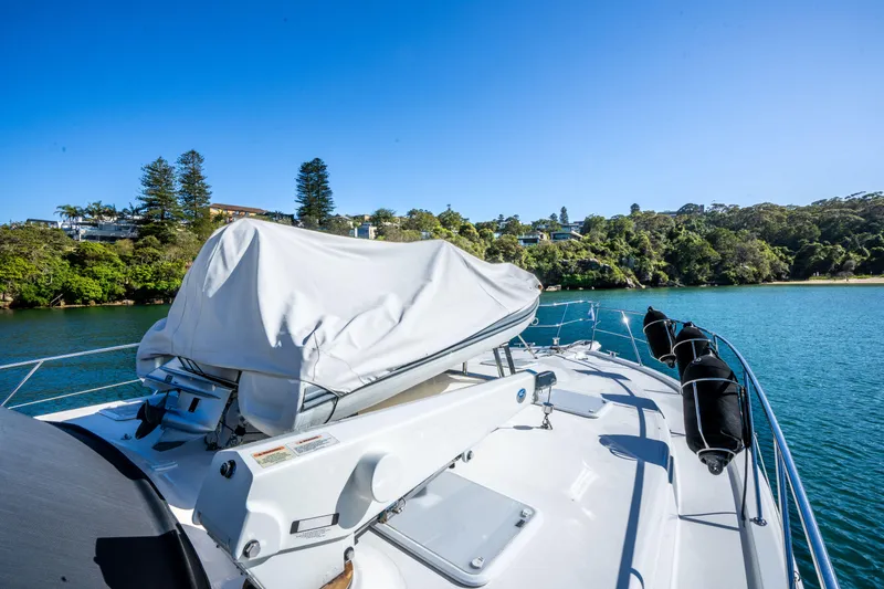 Riviera 61 Enclosed Flybridge Yacht Photos Pics Riviera 61 Enclosed Flybridge yacht on serene water, 2011 model, with lush greenery in the background.