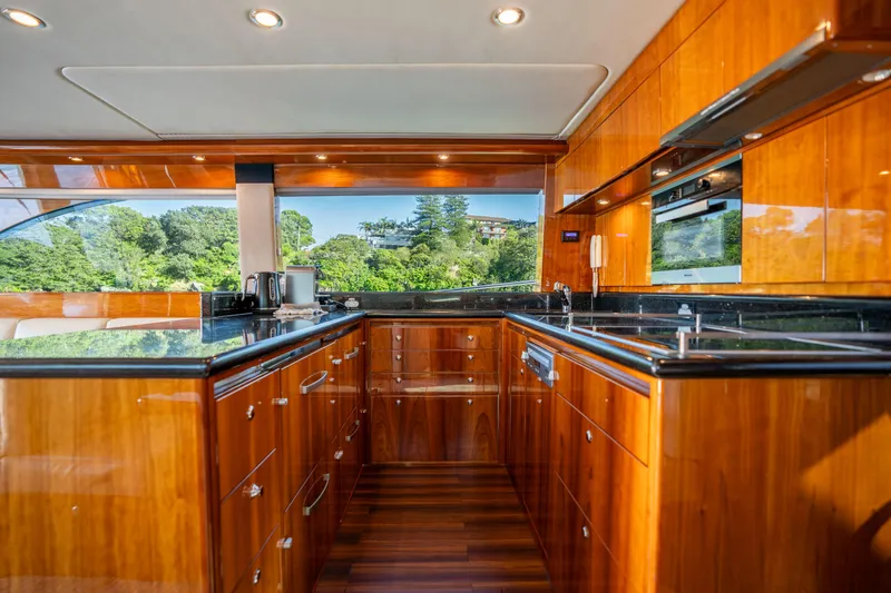 Riviera 61 Enclosed Flybridge Yacht Photos Pics Luxurious kitchen interior of 2011 Riviera 61 Enclosed Flybridge yacht with wood cabinetry and modern appliances.