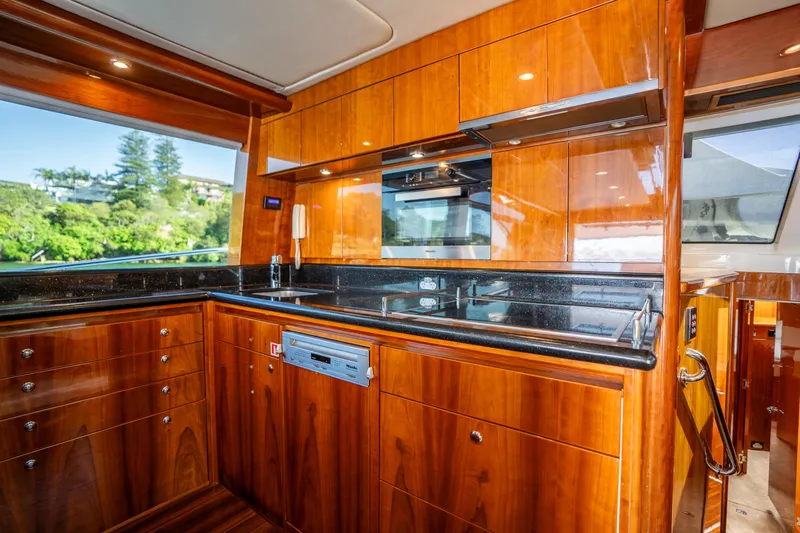 Riviera 61 Enclosed Flybridge Yacht Photos Pics Luxurious kitchen interior of 2011 Riviera 61 Enclosed Flybridge yacht with wood cabinetry.