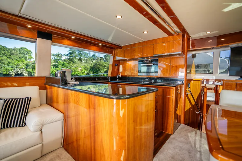 Riviera 61 Enclosed Flybridge Yacht Photos Pics Luxurious interior of 2011 Riviera 61 Enclosed Flybridge yacht with wood finishes and modern amenities.