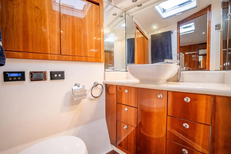 Riviera 61 Enclosed Flybridge Yacht Photos Pics Luxurious bathroom in 2011 Riviera 61 Enclosed Flybridge yacht with wooden cabinetry and modern fixtures.