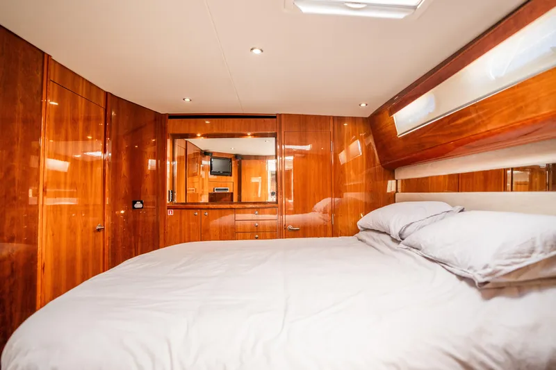 Riviera 61 Enclosed Flybridge Yacht Photos Pics Luxurious bedroom interior of 2011 Riviera 61 Enclosed Flybridge yacht with wooden finish.