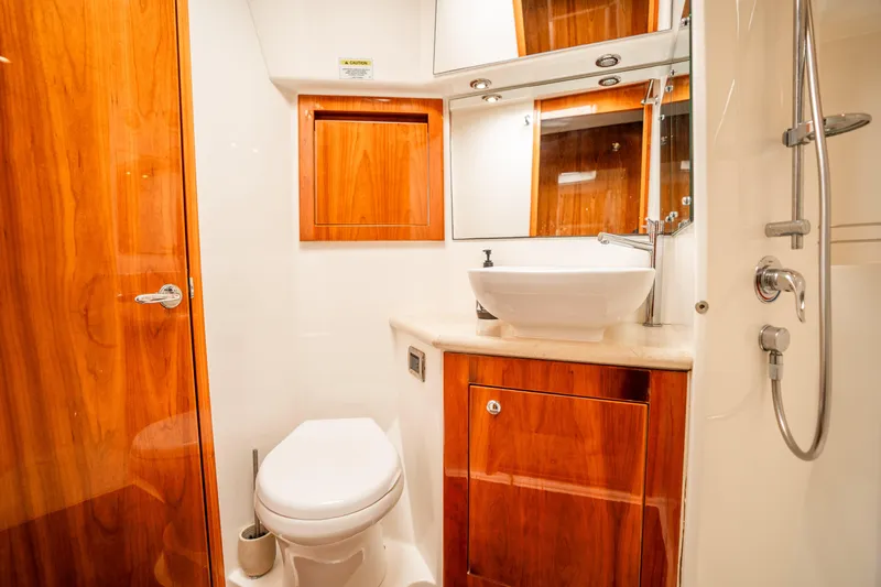 Riviera 61 Enclosed Flybridge Yacht Photos Pics Luxurious bathroom in 2011 Riviera 61 Enclosed Flybridge yacht with wood accents and modern fixtures.