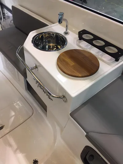  Yacht Photos Pics Compact kitchenette on Hanover 305 boat, featuring sink, faucet, and wooden cutting board, 2025 model.