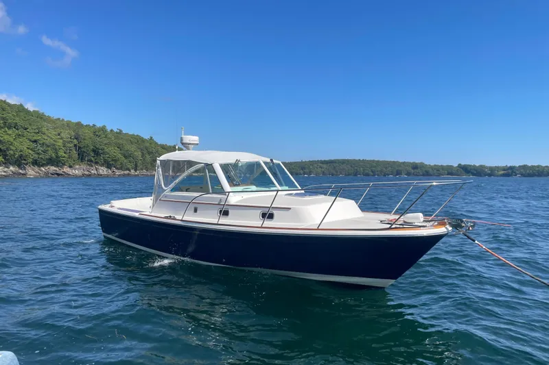 Tenacity Yacht Photos Pics 2012 Hunt Surfhunter boat on calm water with forested shoreline.