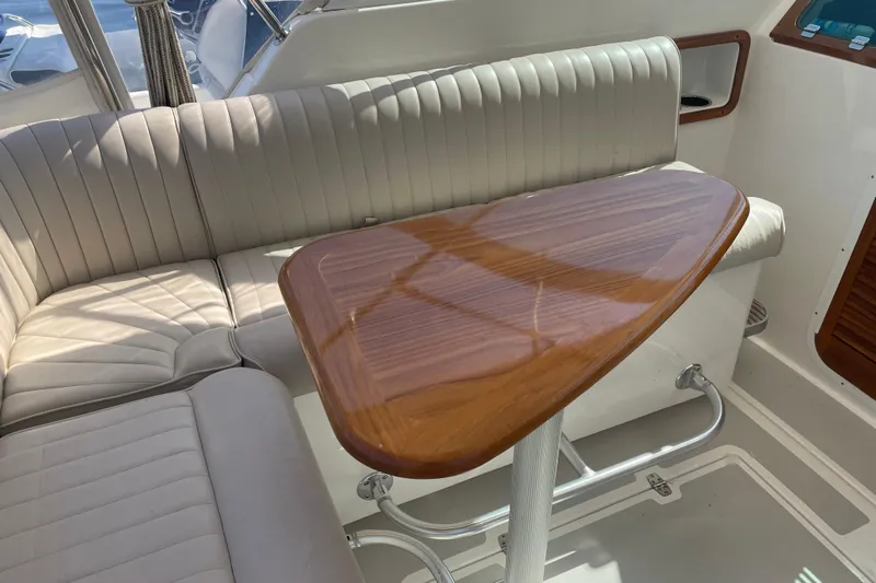 Tenacity Yacht Photos Pics Luxurious interior of 2012 Hunt Surfhunter boat with elegant wood table and cushioned seating.