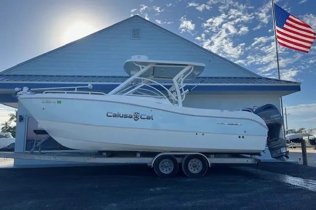  Yacht Photos Pics 2022 World Cat 255 DC boat on trailer, parked outside with American flag in background.