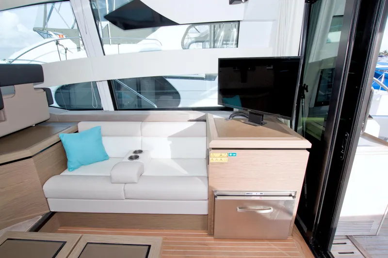 Gail Force Yacht Photos Pics Interior of 2019 Beneteau Gran Turismo 50 yacht with white seating and TV.
