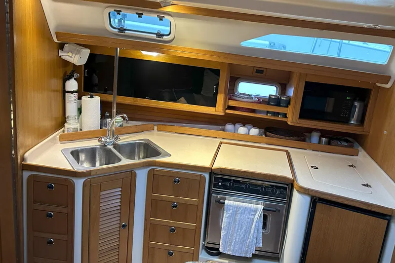 Take Five Yacht Photos Pics Interior view of a 1999 Catalina 42 MkII yacht kitchen with wooden cabinetry.