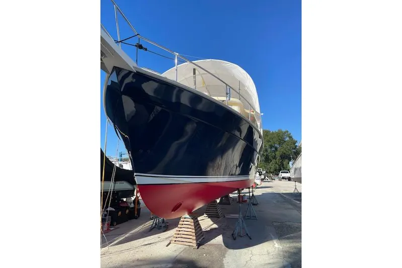 Perseus Yacht Photos Pics 2008 Mainship 34 Trawler Hardtop on dry dock, blue hull, red bottom, clear sky.