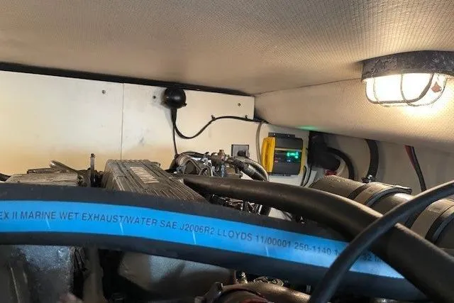 Perseus Yacht Photos Pics Engine room of 2008 Mainship 34 Trawler Hardtop with visible exhaust hose and lighting.