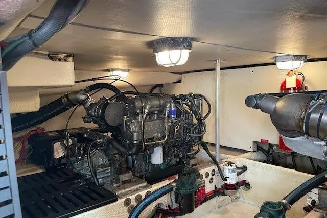 Perseus Yacht Photos Pics Engine room of 2008 Mainship 34 Trawler Hardtop, featuring well-maintained machinery and lighting.
