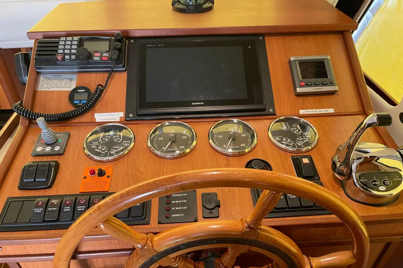 Perseus Yacht Photos Pics 2008 Mainship 34 Trawler Hardtop helm with gauges, controls, and wooden steering wheel.