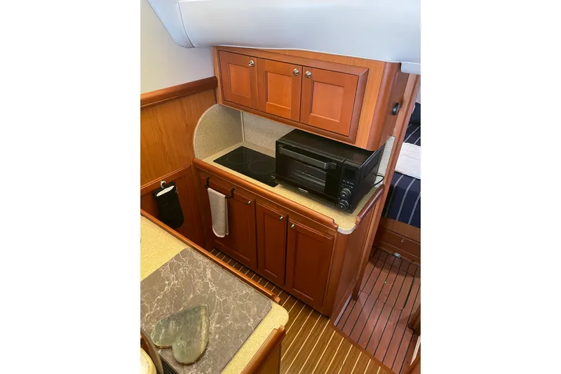 Perseus Yacht Photos Pics 2008 Mainship 34 Trawler Hardtop galley with wood cabinetry and modern appliances.