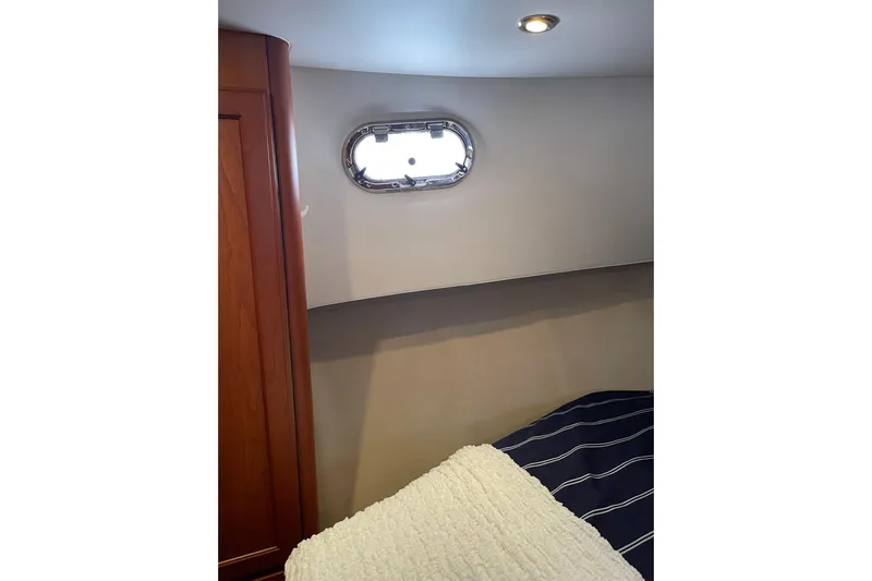 Perseus Yacht Photos Pics 2008 Mainship 34 Trawler Hardtop cabin interior with porthole and cozy bedding.