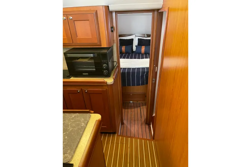 Perseus Yacht Photos Pics 2008 Mainship 34 Trawler Hardtop interior with wood cabinetry and cozy bedroom.