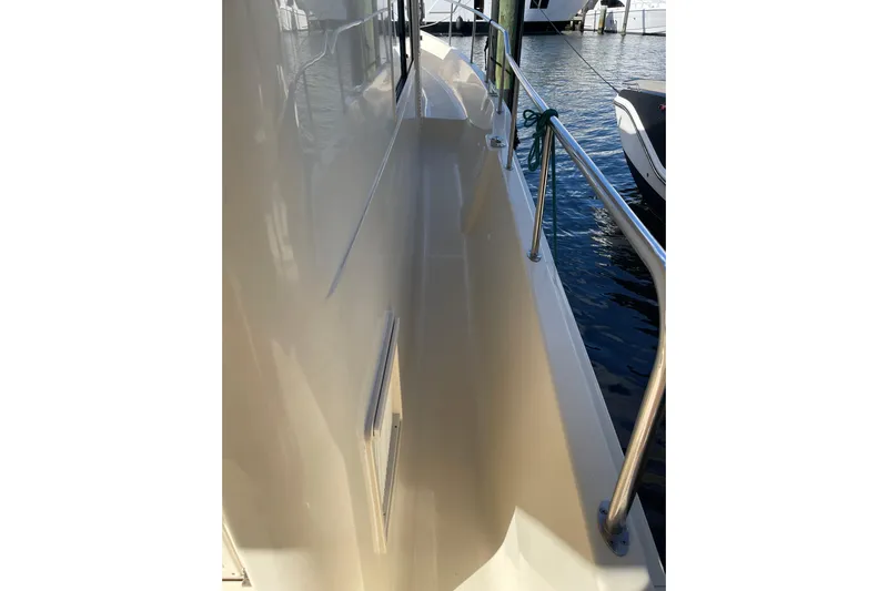 Perseus Yacht Photos Pics 2008 Mainship 34 Trawler Hardtop side deck with railing, docked by the water.