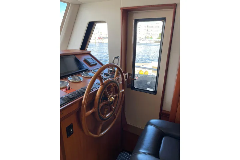 Perseus Yacht Photos Pics 2008 Mainship 34 Trawler Hardtop helm with wooden steering wheel and navigation instruments.