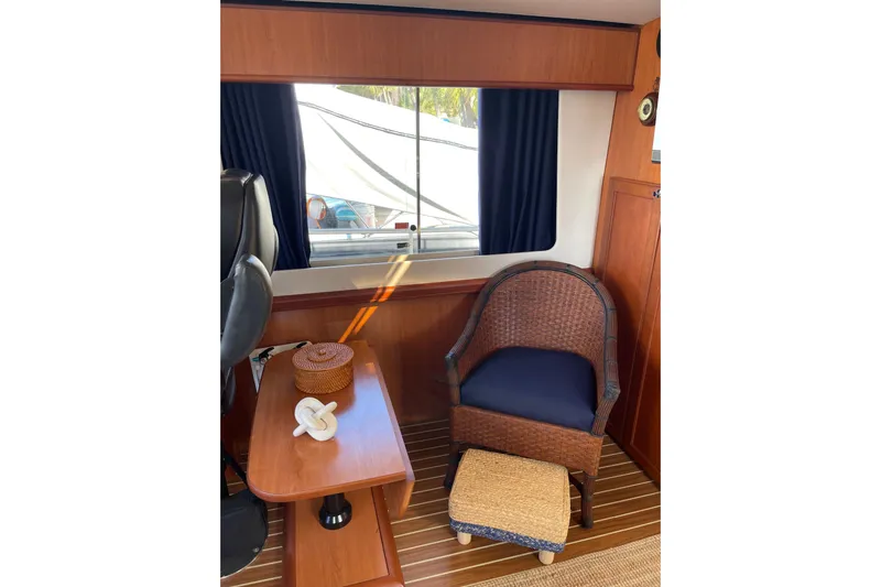 Perseus Yacht Photos Pics Interior of 2008 Mainship 34 Trawler Hardtop with wicker chair and wooden table.