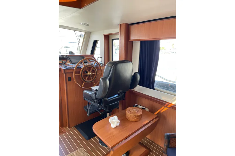 Perseus Yacht Photos Pics 2008 Mainship 34 Trawler Hardtop interior with helm, wooden wheel, and captain's chair.