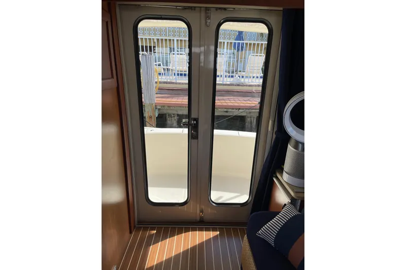 Perseus Yacht Photos Pics Interior view of 2008 Mainship 34 Trawler Hardtop with glass doors and wooden flooring.