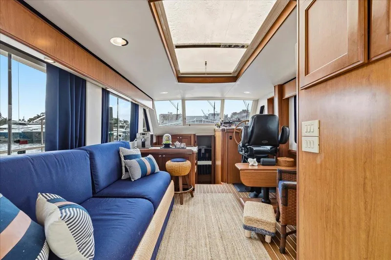 Perseus Yacht Photos Pics Interior of 2008 Mainship 34 Trawler Hardtop with blue sofa and helm station.
