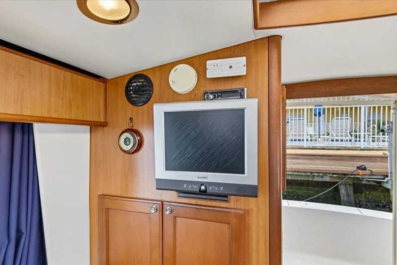 Perseus Yacht Photos Pics Interior of 2008 Mainship 34 Trawler Hardtop with TV and wooden cabinetry.