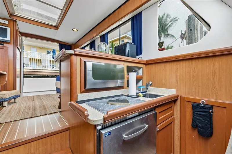 Perseus Yacht Photos Pics 2008 Mainship 34 Trawler Hardtop interior with kitchenette, featuring wood finish and modern appliances.