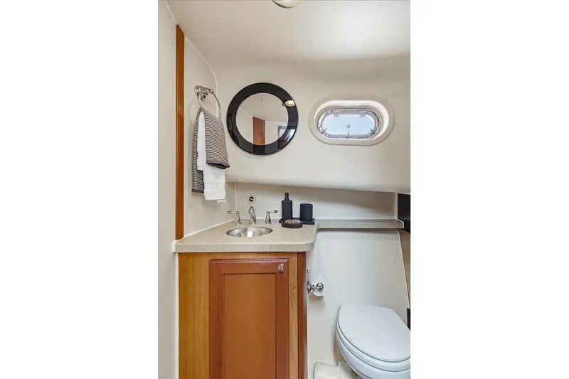 Perseus Yacht Photos Pics Bathroom interior of 2008 Mainship 34 Trawler Hardtop with sink, mirror, and porthole window.
