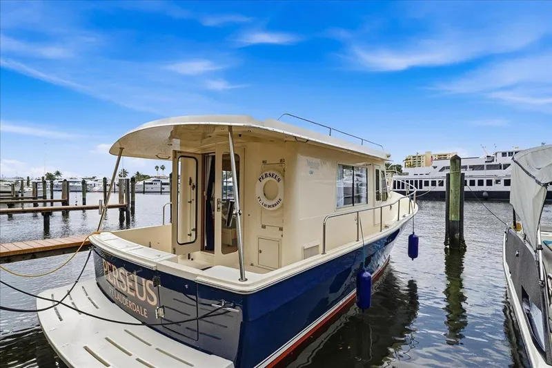 Perseus Yacht Photos Pics 2008 Mainship 34 Trawler Hardtop docked at marina under clear blue sky.