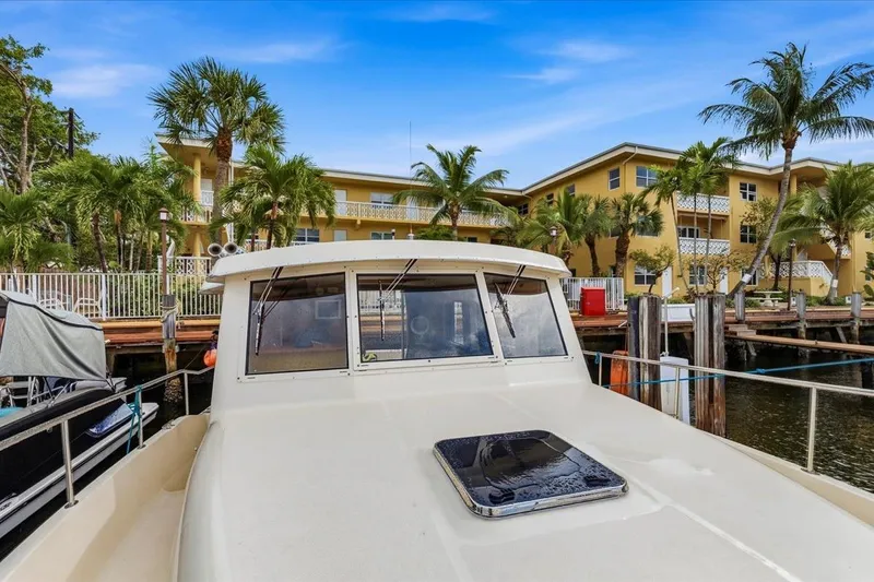 Perseus Yacht Photos Pics 2008 Mainship 34 Trawler Hardtop docked near tropical waterfront property.
