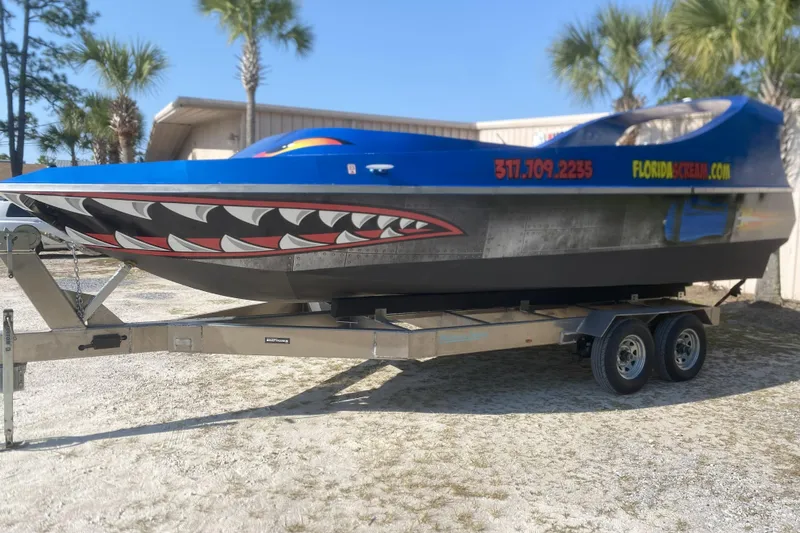  Yacht Photos Pics 2022 Smoky Mountain 16 Passenger boat with shark design on trailer, palm trees in background.