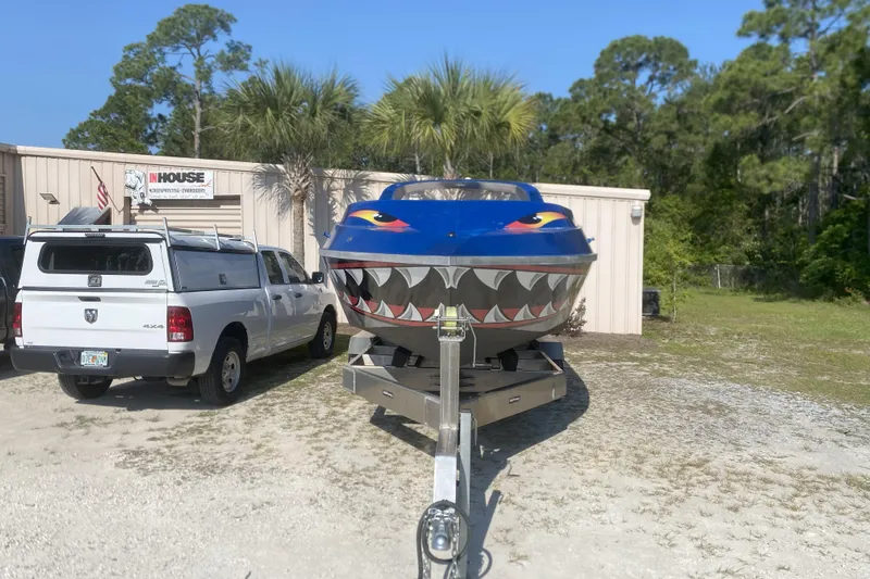  Yacht Photos Pics 2022 Smoky Mountain 16 Passenger boat with shark design, parked beside a white truck.