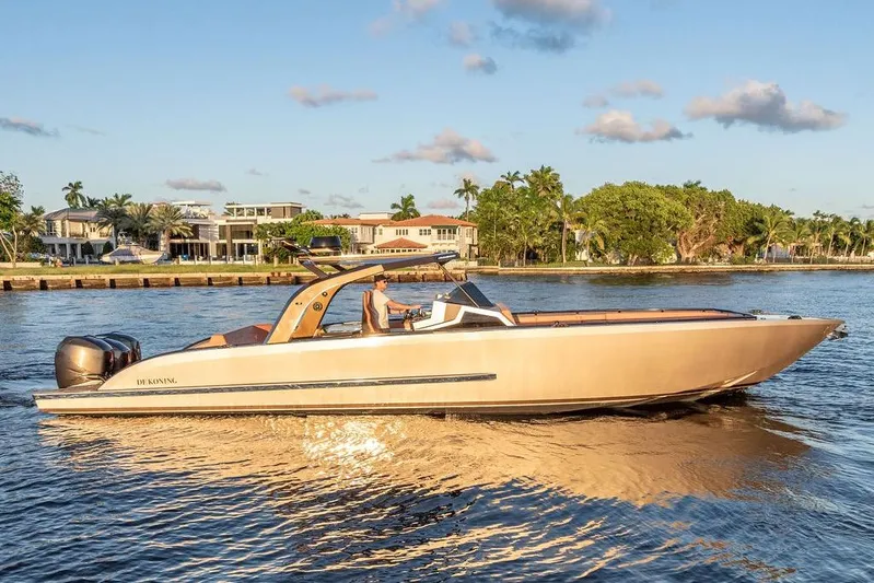  Yacht Photos Pics 2023 DeKoning 43 luxury boat cruising on a sunny waterfront.