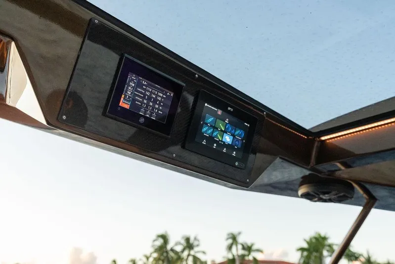  Yacht Photos Pics Control panel of 2023 DeKoning 43 boat with digital displays and scenic background.