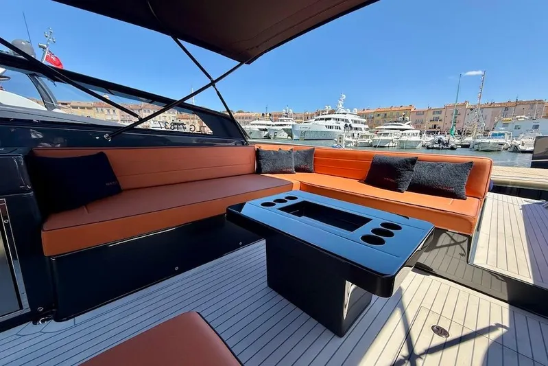 Must Yacht Photos Pics Luxurious 2024 VanDutch 40 yacht interior with orange seating and sleek black table in marina.