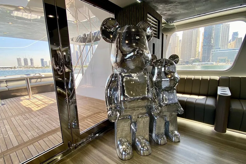  Yacht Photos Pics Luxurious yacht interior with shiny bear sculptures, city skyline view, and elegant seating.