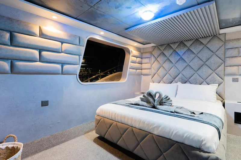  Yacht Photos Pics Luxurious bedroom interior on 2002 Custom Yacht 125, featuring elegant decor and ambient lighting.