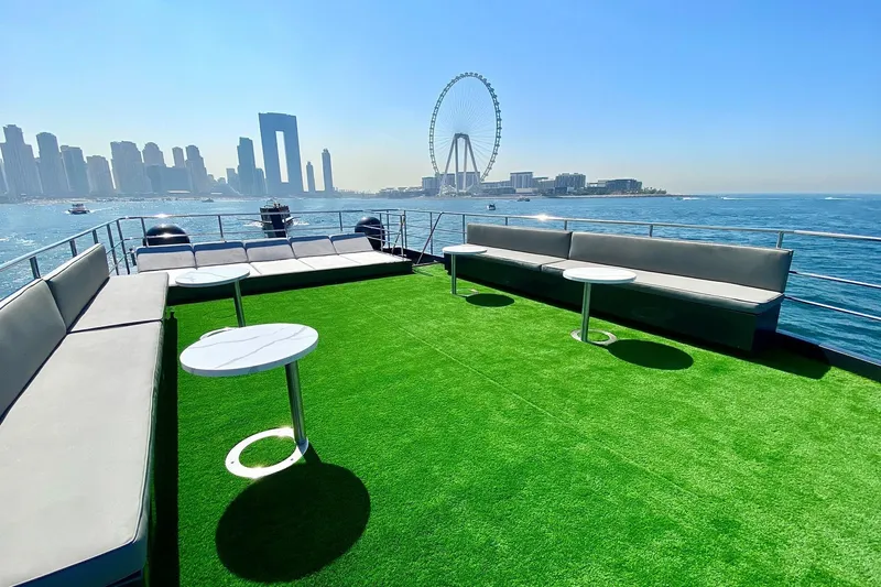  Yacht Photos Pics Luxurious Custom Yacht 125 deck with green turf, city skyline, and Ferris wheel view.
