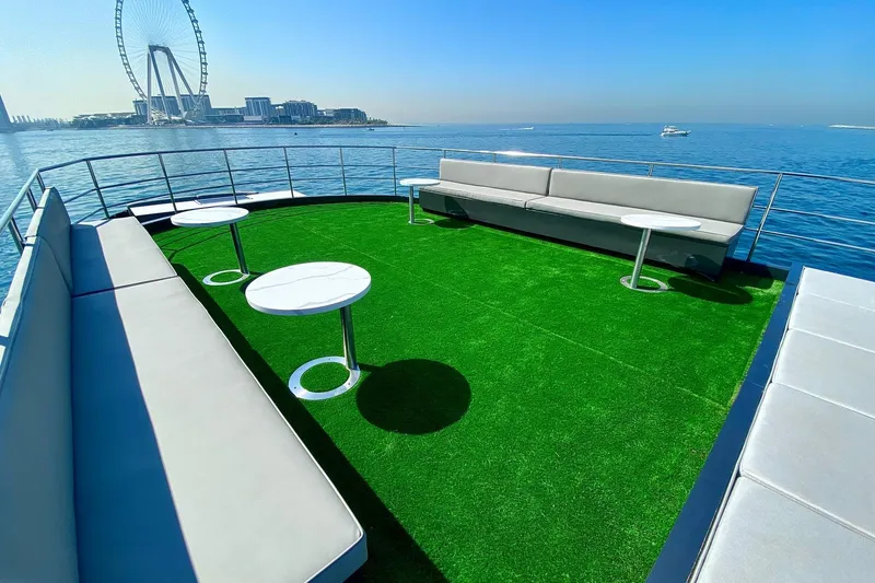  Yacht Photos Pics Luxurious Custom Yacht 125 deck with green turf, modern seating, and ocean view, 2002 model.