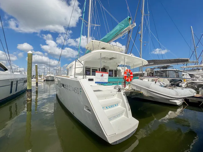 Sunshine Yacht Photos Pics 2017 Lagoon 450 F catamaran docked at marina under blue sky.