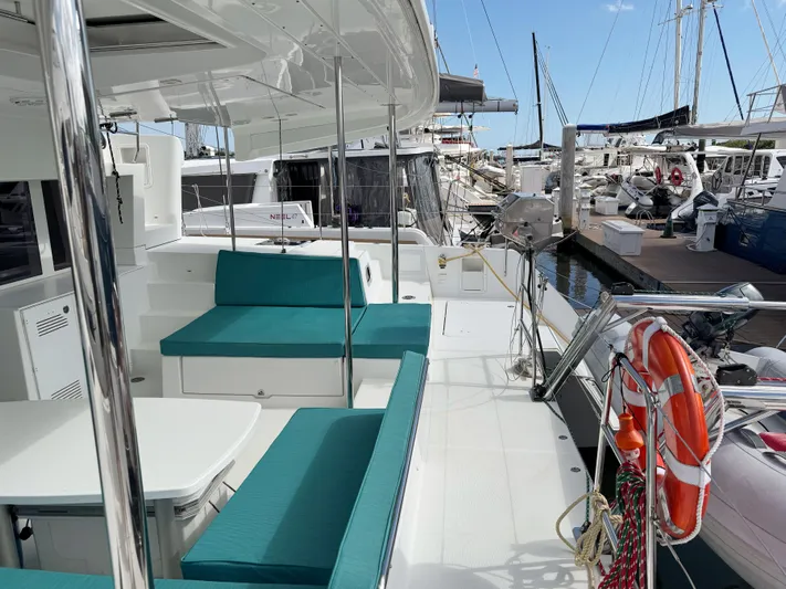 Sunshine Yacht Photos Pics 2017 Lagoon 450 F catamaran with teal seating, docked at a marina.